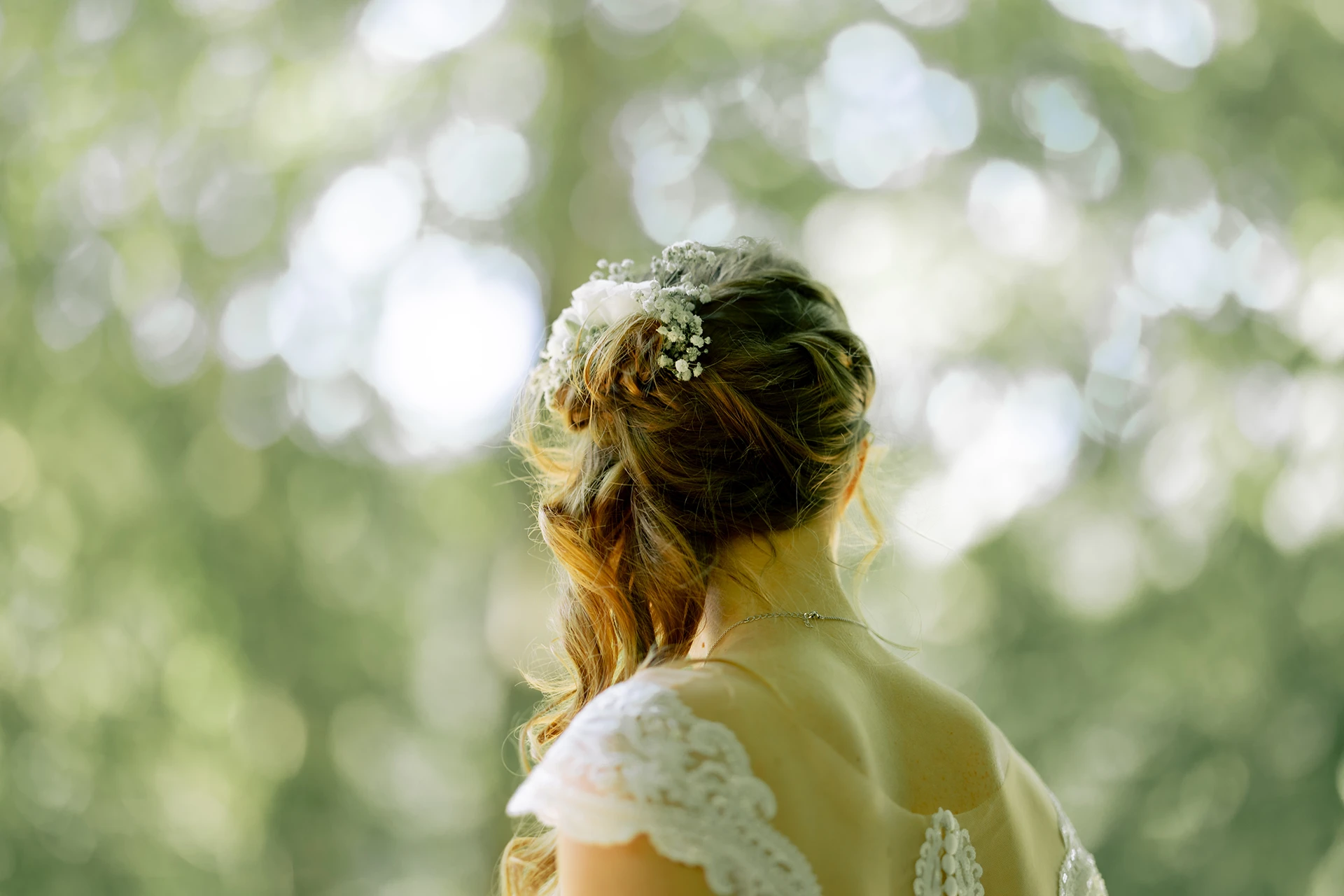 Die Braut von hinten, man ereknnt den Blumenschmuck im Haar.